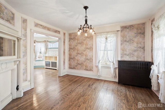 22 Booream Ave, Milltown, NJ 08850 - unfurnished dining area featuring wood finished floors, radiator heating unit, a notable chandelier, and a wealth of natural light