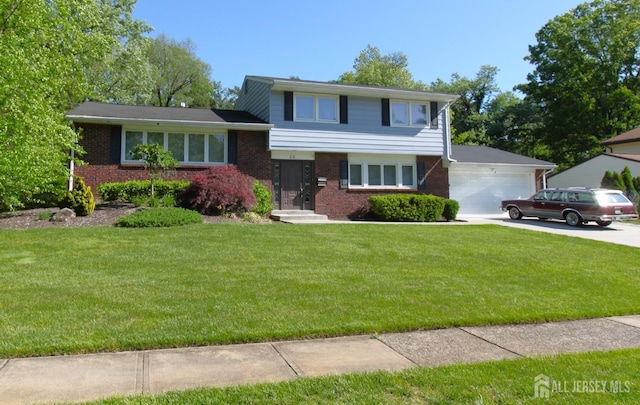 tri-level home featuring brick siding, a garage, a front lawn, and driveway