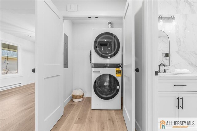 737 Prospect Rd Unit 737A, Monroe, NJ 08831 - washroom featuring stacked washer / dryer, light wood-style floors, a baseboard radiator, baseboards, and electric panel
