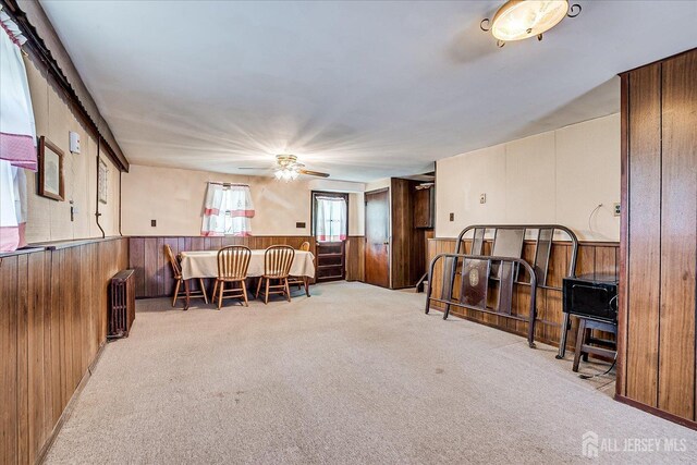 6 N Minnisink Ave, Sayreville, NJ 08859 - dining space with radiator heating unit, carpet floors, wooden walls, wainscoting, and a ceiling fan