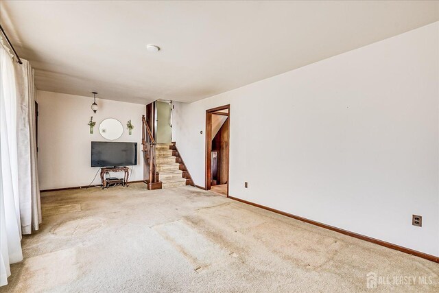 6 N Minnisink Ave, Sayreville, NJ 08859 - unfurnished living room with carpet flooring, stairway, and baseboards