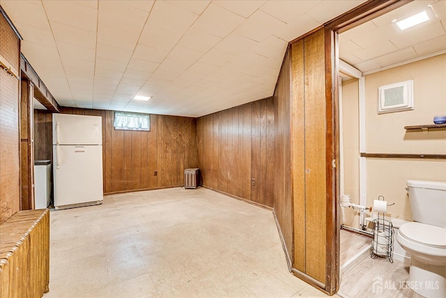 6 N Minnisink Ave, Sayreville, NJ 08859 - basement featuring freestanding refrigerator, radiator, wooden walls, and light flooring