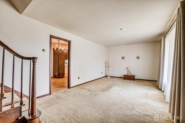 6 N Minnisink Ave, Sayreville, NJ 08859 - spare room with light carpet, stairway, baseboards, and a chandelier
