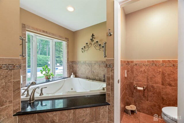 28 Sugarbush Rd, Howell, NJ 07731 - full bathroom featuring a jetted tub, tile walls, a wainscoted wall, and tile patterned flooring