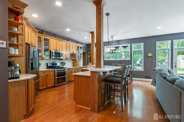 28 Sugarbush Rd, Howell, NJ 07731 - kitchen featuring stainless steel appliances, decorative columns, open floor plan, light countertops, and a kitchen bar