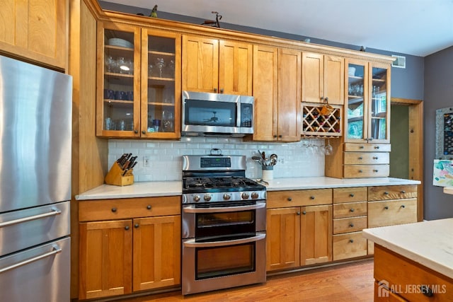 28 Sugarbush Rd, Howell, NJ 07731 - kitchen with stainless steel appliances, light countertops, backsplash, and brown cabinets