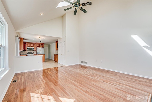 12 Carriage Dr, Piscataway, NJ 08854 - unfurnished living room featuring light wood-style floors, a sink, high vaulted ceiling, ceiling fan, and baseboards