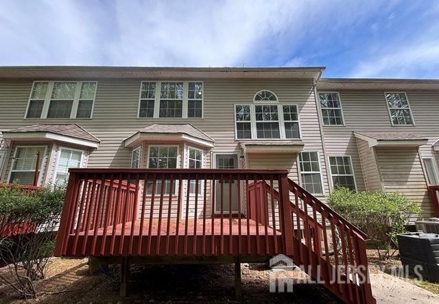 rear view of property featuring central air condition unit and a deck