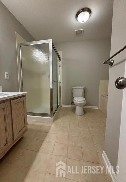 full bath with visible vents, tile patterned flooring, a stall shower, vanity, and toilet