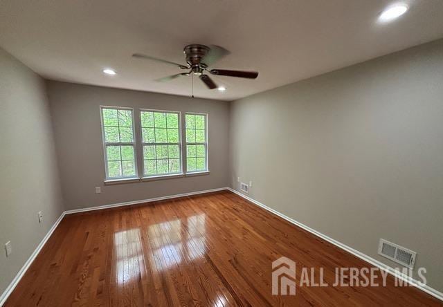 spare room with a ceiling fan, visible vents, wood finished floors, baseboards, and recessed lighting