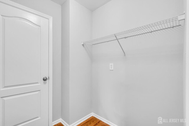 242 Hawthorne Rd, North Brunswick, NJ 08902 - laundry area featuring wood finished floors and baseboards