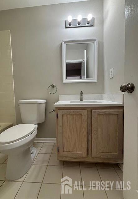 full bath featuring a shower, tile patterned floors, baseboards, vanity, and toilet