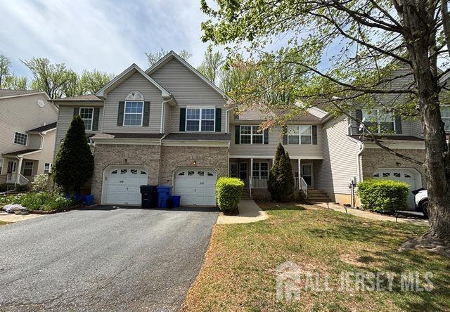 view of front of home with an attached garage, a front lawn, and aphalt driveway