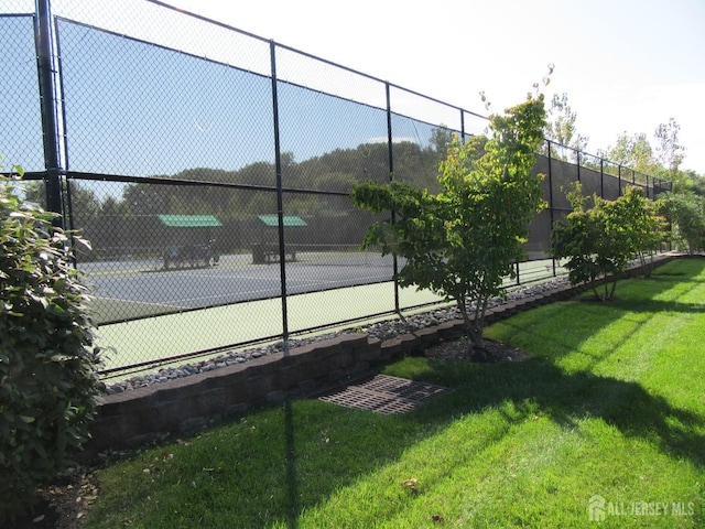 view of sport court featuring a lawn