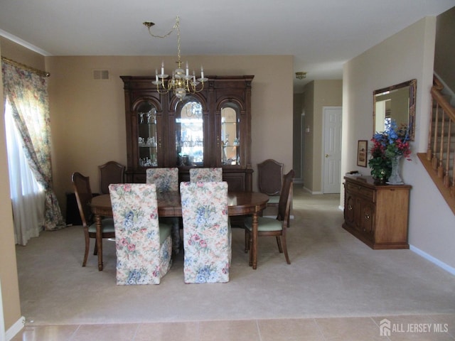 dining area with light carpet and a notable chandelier