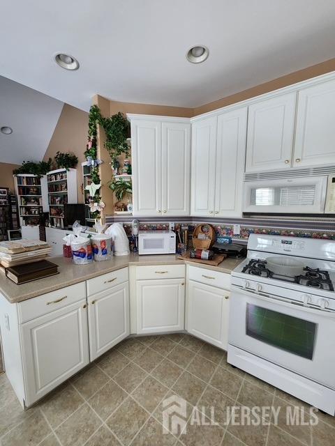 kitchen with white appliances and white cabinets