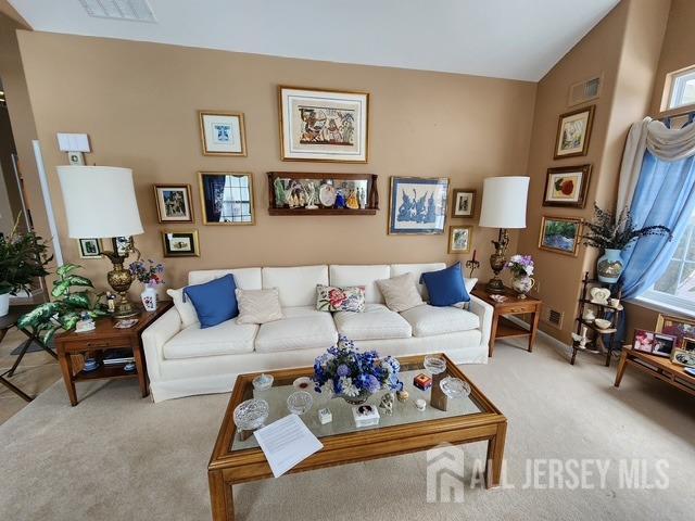 living room with vaulted ceiling and carpet flooring