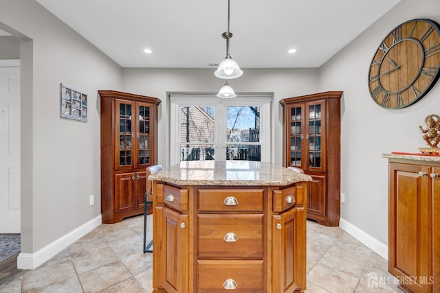 kitchen with a kitchen island, light stone counters, pendant lighting, glass insert cabinets, and recessed lighting