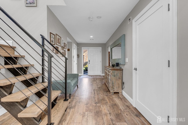 hallway with stairs, wood-type flooring, recessed lighting, and baseboards