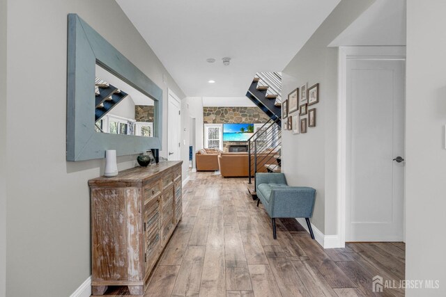 hall with wood finished floors, stairway, baseboards, and recessed lighting