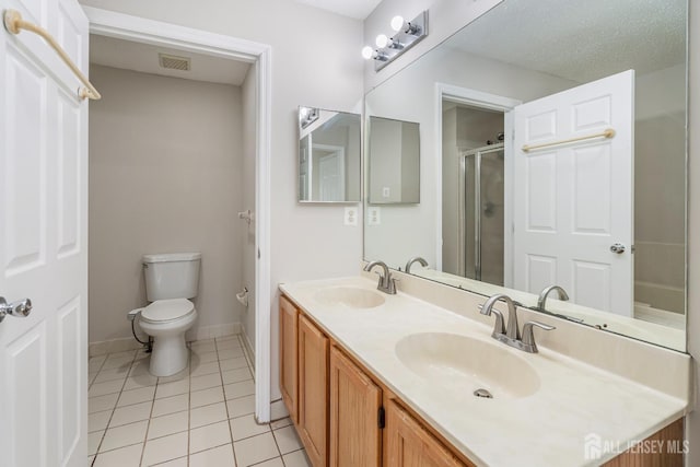 bathroom featuring tile patterned flooring, toilet, a shower stall, baseboards, and double vanity