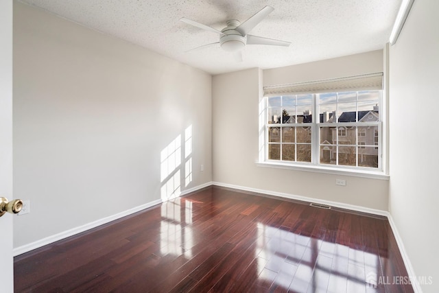 spare room featuring ceiling fan, wood finished floors, visible vents, and baseboards