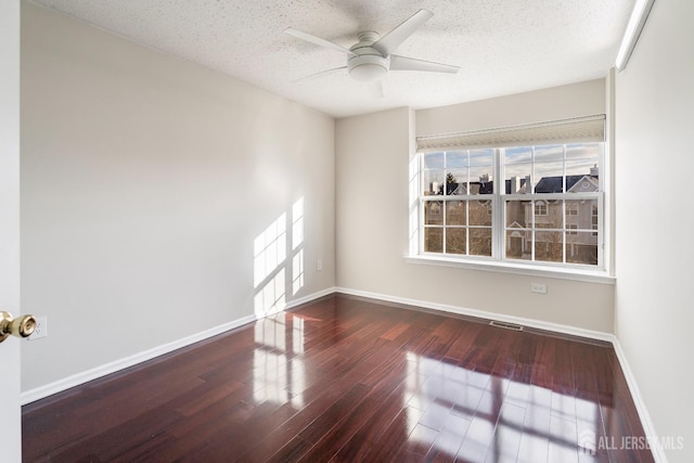 empty room featuring wood finished floors, baseboards, a textured ceiling, and ceiling fan
