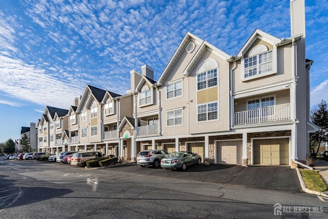 view of property featuring a residential view and uncovered parking