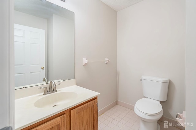 half bathroom with toilet, tile patterned floors, vanity, baseboards, and a textured ceiling