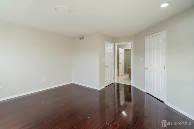 empty room with baseboards, wood finished floors, and recessed lighting