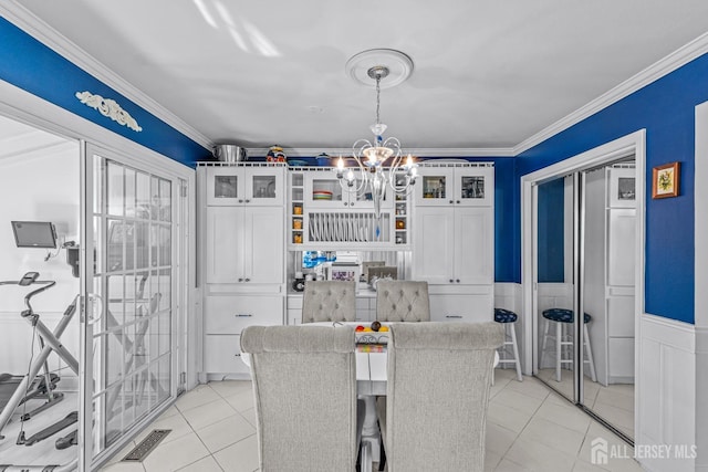 dining area featuring an inviting chandelier, ornamental molding, and light tile patterned flooring