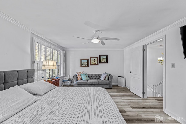 bedroom featuring ceiling fan, light hardwood / wood-style floors, and crown molding