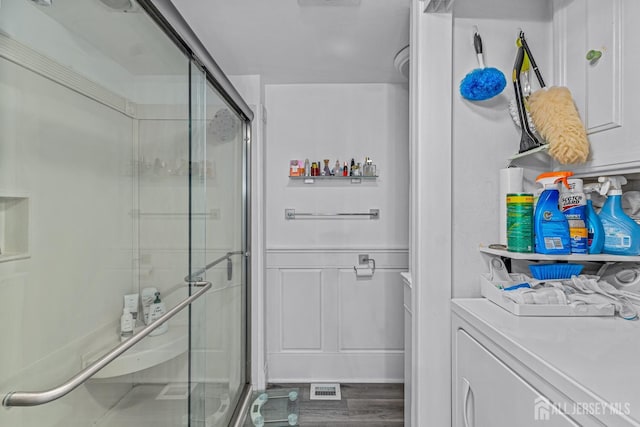 clothes washing area with hardwood / wood-style floors and washer / dryer