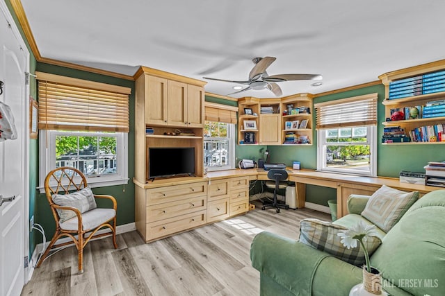 office area with crown molding, plenty of natural light, ceiling fan, and built in desk