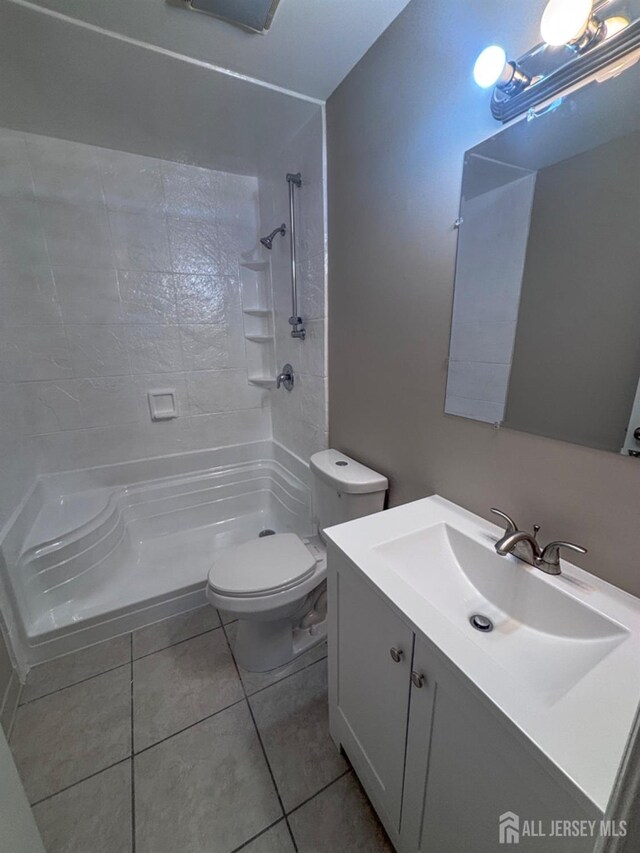 full bath with tile patterned flooring, vanity, toilet, and walk in shower