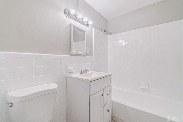 full bathroom with toilet, shower / bath combination, vanity, tile walls, and wainscoting