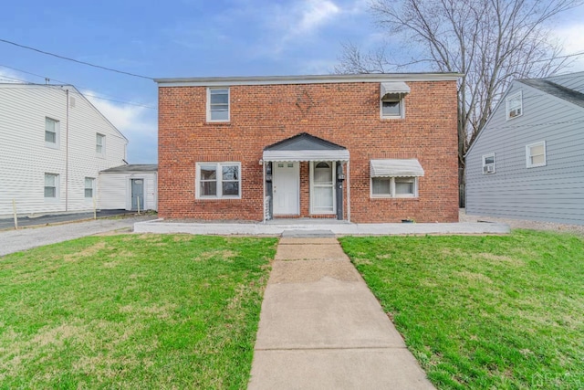 view of front of home featuring a front lawn and brick siding