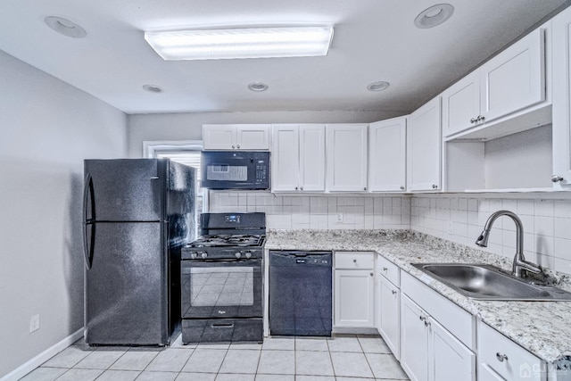 kitchen with light tile patterned floors, tasteful backsplash, white cabinets, a sink, and black appliances