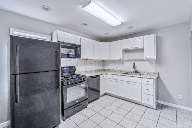 kitchen featuring black appliances, white cabinetry, and a sink