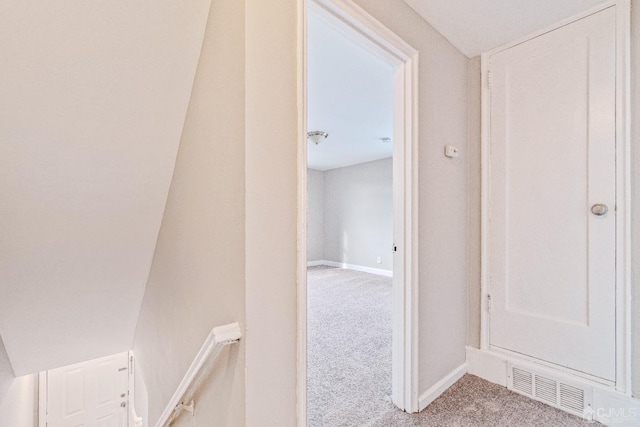 hall with carpet floors, visible vents, and baseboards