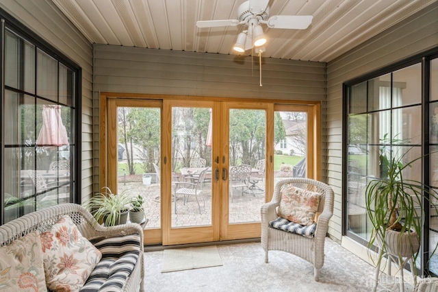 sunroom / solarium with carpet floors, ceiling fan, and french doors