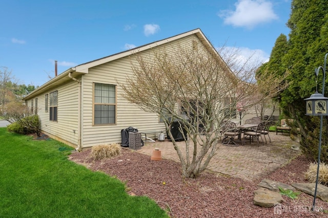 rear view of house with a lawn and a patio