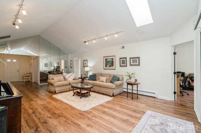 living room with track lighting, light wood-style flooring, vaulted ceiling with skylight, and a baseboard radiator