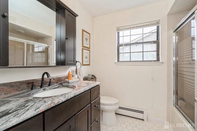 bathroom with tile patterned flooring, vanity, toilet, combined bath / shower with glass door, and a baseboard heating unit