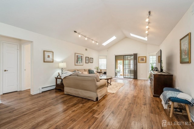 living area with wood finished floors, baseboards, lofted ceiling with skylight, baseboard heating, and rail lighting