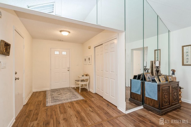 foyer entrance with baseboards and wood finished floors