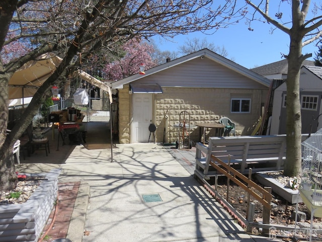 rear view of house with fence, a gate, and a patio