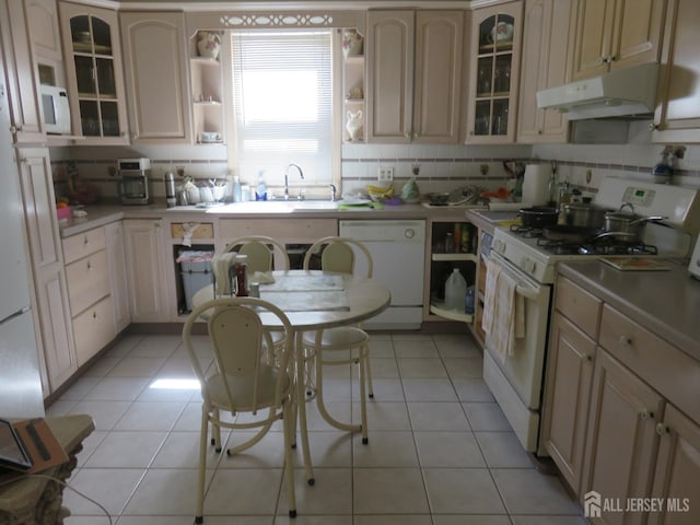 kitchen with white appliances, under cabinet range hood, open shelves, and decorative backsplash