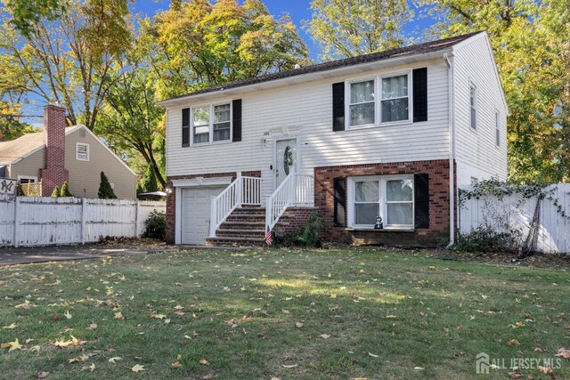 raised ranch featuring a front lawn and a garage