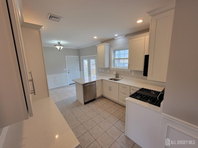 kitchen with stainless steel dishwasher, white cabinets, kitchen peninsula, and stove